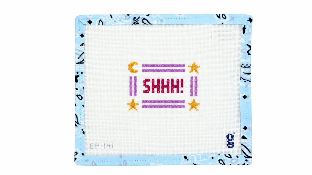 Shop Shhh by goodpoint, a stitch-painted 13 mesh needlepoint canvas with a 2.9" x 4.3" design. Includes a Bohin needle and bound edges. Threads not included.