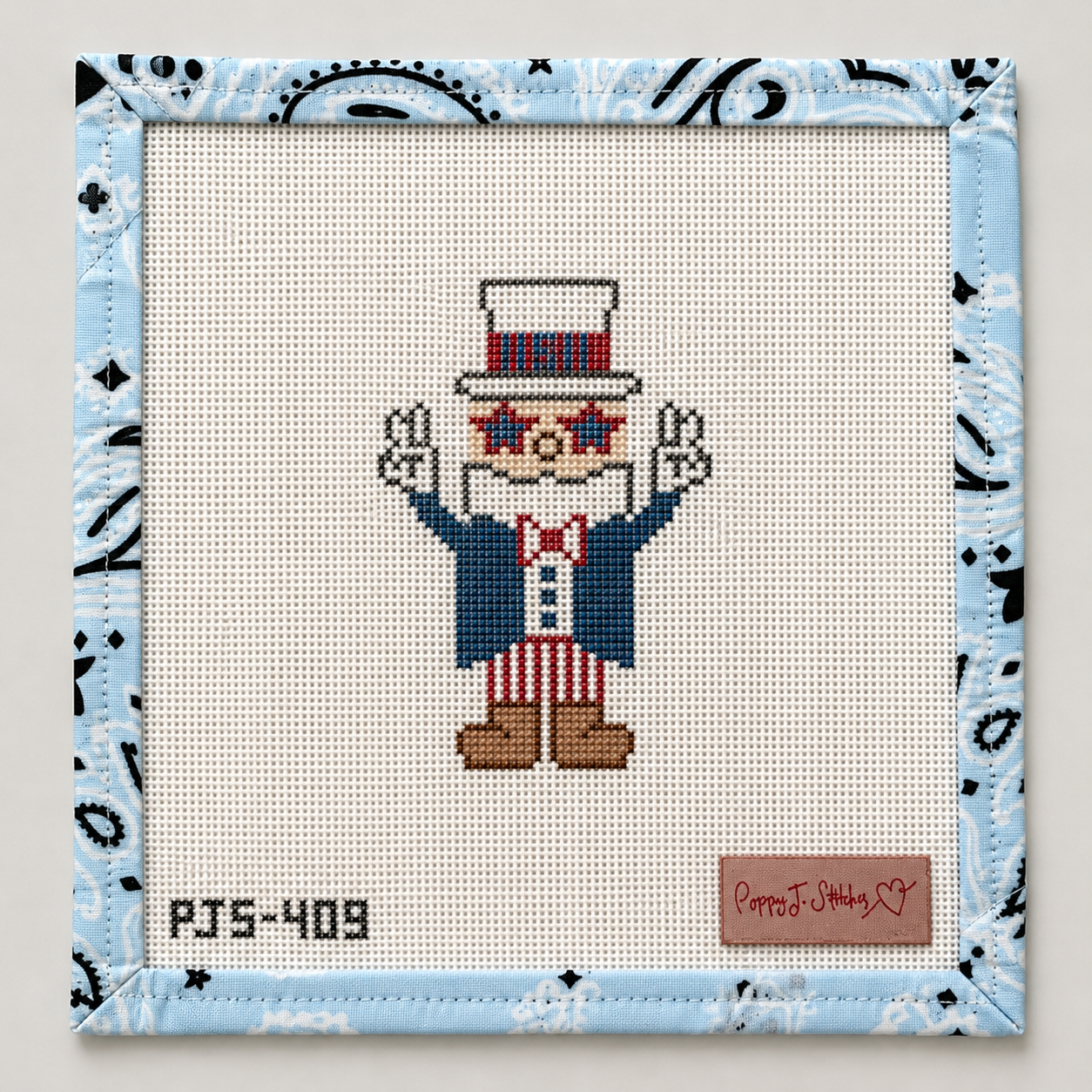 Hand-painted Influencer Uncle Sam needlepoint canvas by Poppy J Stitches. 18 mesh, 4x3" design. Threads not included. Shop premium patriotic canvases.