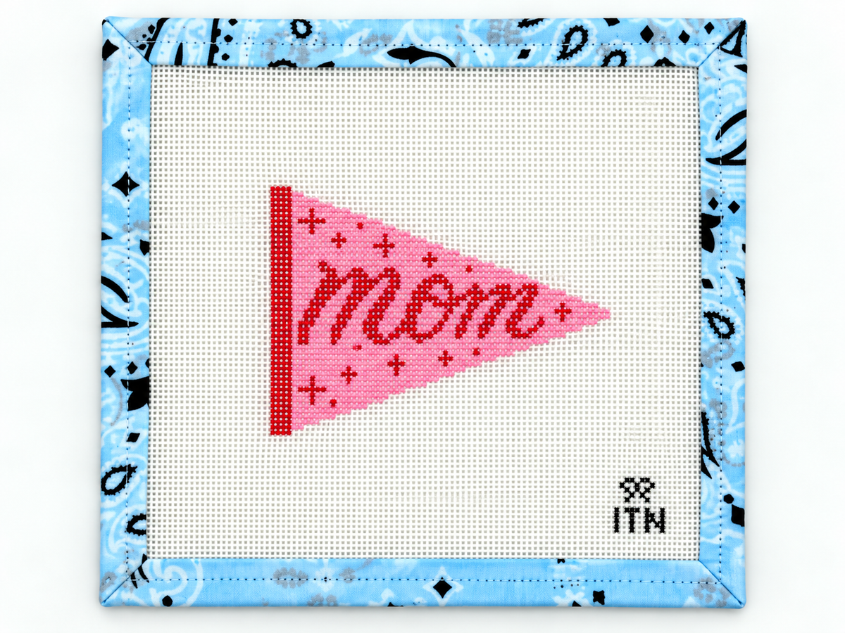 Stitch a Mom pennant needlepoint canvas by Ivy Thread. The 3.3 x 2.5-inch design is ideal for finishing as a charm, patch, or ornament.
