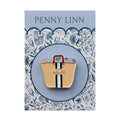 Gold bag-shaped pin with 'H' on a decorative card with 'Penny Linn' branding.