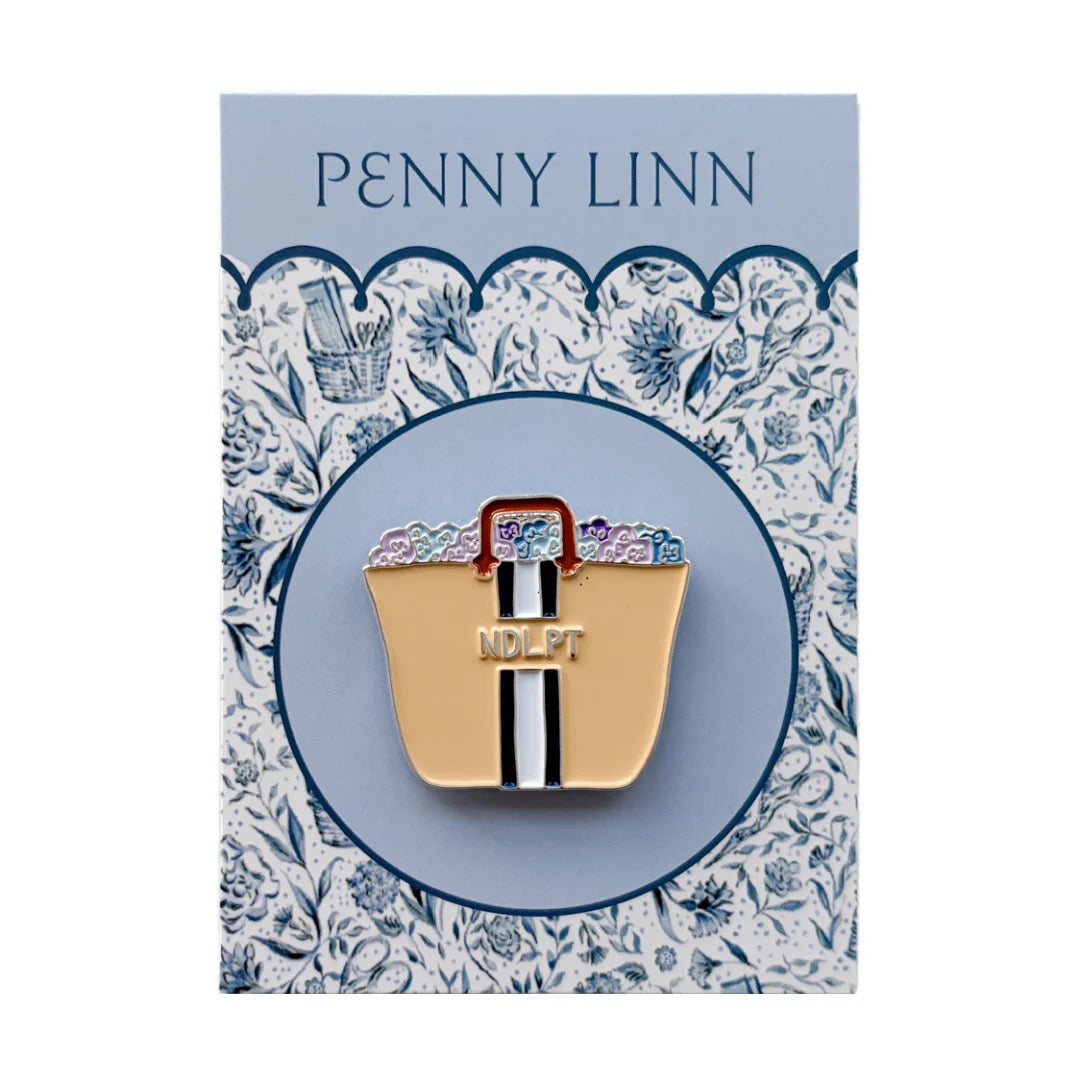 Gold bag-shaped pin with 'H' on a decorative card with 'Penny Linn' branding.